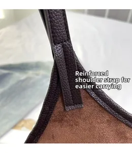 Macro detail of reinforced shoulder strap stitching on brown lychee texture tote bag