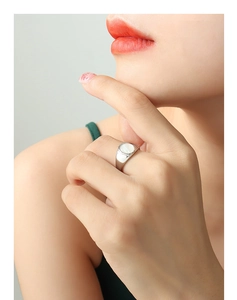Close-up of titanium steel ring with white shell inlay worn on index finger
