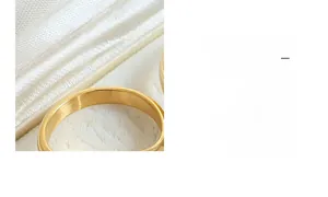Macro view of gold-plated titanium ring with brushed texture on white satin lining