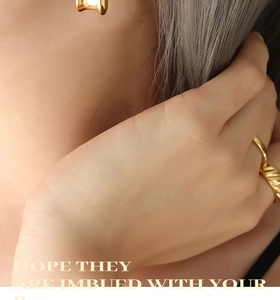 Close-up of a gold twisted textured ring worn on a finger with warm soft lighting