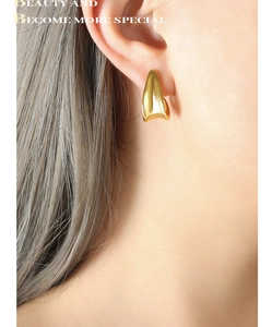 Detail of a gold-plated J-shaped hoop earring on ear with polished metallic finish