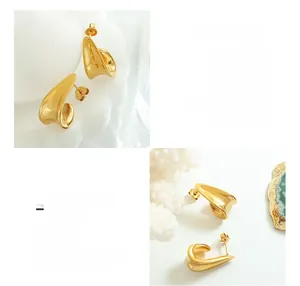 Detailed close-up of gold-plated J-shaped titanium steel earrings on a marble surface