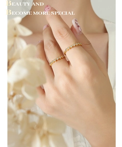 Close-up of elegant gold plated wavy eternity rings with sparkling zircon stones