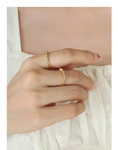 Close-up of elegant gold plated rings with sparkling zircon inlay on white lace fabric
