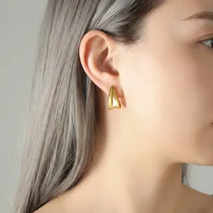 Minimalist gold-plated stainless steel curved earrings shown on model profile