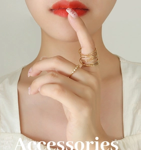 Detailed view of layered gold spring coil ring and minimalist five-stone zircon band