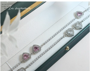 Dettaglio macro della collana d'argento con cristalli a cuore rosa e pavé di zirconi