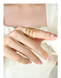 Close-up of elegant gold layered coil spring ring worn on model finger in French style