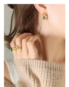 Mannequin portant des boucles d'oreilles émeraude zircon et une bague dorée ajustable