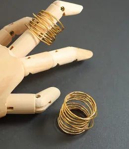 Close-up of golden multi-layer spiral spring ring on a wooden mannequin hand