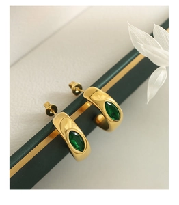 Détail de boucles d'oreilles en C dorées 18K avec zircons marquise vert émeraude