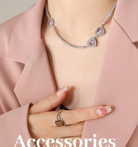 Dettaglio della collana d'argento con cuori rosa e anello con pietra quadrata sulla modella