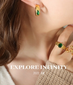 Vue détaillée de boucles d'oreilles vintage dorées avec zircon émeraude sur un modèle