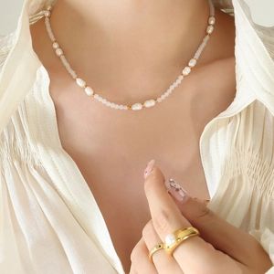 Collana di perle barocche e pietre di luna con dettagli dorati su modella elegante