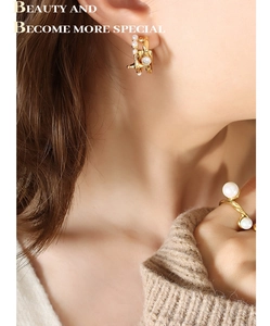 Detail of French vintage irregular C-shape earrings with pearls and matching gold ring