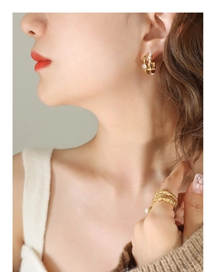 Close-up of French vintage irregular C-shape earrings with pearls and zircon in gold finish