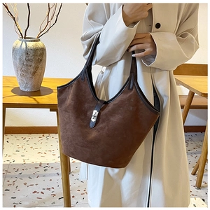 Detail showing high-capacity suede tote bag with metal buckle and leather handles