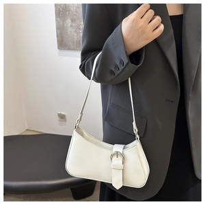 Detailed close-up of a white leather crescent shoulder bag with silver buckle details
