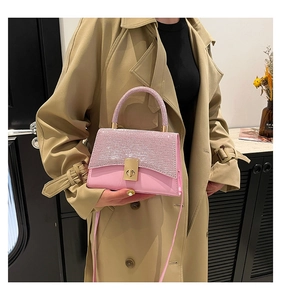Close-up of pink sequined crossbody bag featuring a golden twist lock and matte finish