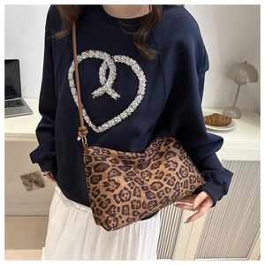 Detailed view of leopard print shoulder bag worn by model in a casual lifestyle setting