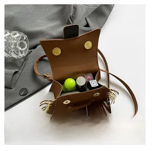 Détail de l'intérieur du sac bandoulière marron à franges avec fermoir magnétique doré