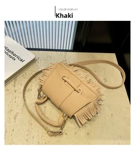 Détail du sac bandoulière en similicuir kaki avec franges élégantes et boucles dorées chic
