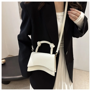 Detail of white structured handbag with signature curved base and knotted handle detail
