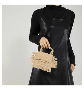 Détails du mini sac bandoulière beige avec des franges et des ferrures dorées