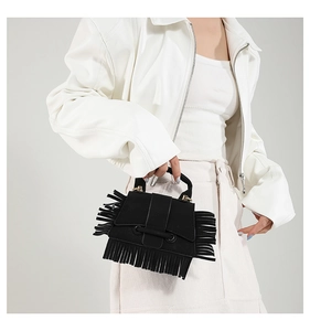 Détail d'un sac à main noir à franges montrant la texture en daim et les longues franges