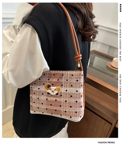 Détail du sac à bandoulière à carreaux roses avec dentelle et écusson mouton porté