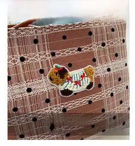 Gros plan d'un sac seau en dentelle à pois avec une jolie broderie de chien teddy