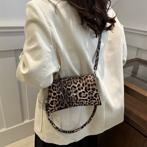Sac bandoulière tendance à motif léopard avec fermoir étoile argentée porté par un mannequin