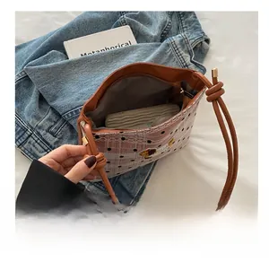 Vue de dessus du sac seau à carreaux rose montrant l'espace pour mobile et cosmétiques