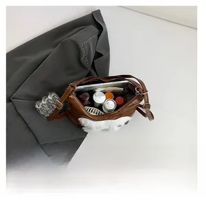 Brown tote bag with white plush trim showing spacious capacity for tablets and cosmetics