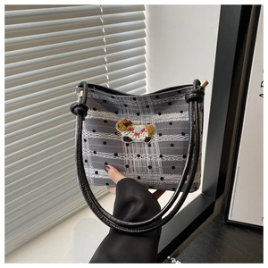Détail du sac seau minimaliste à motif à pois et broderie de chien en peluche