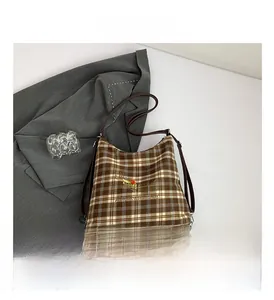 Détail du sac cabas rétro à carreaux avec broderie de chiot animé et bandoulière en cuir