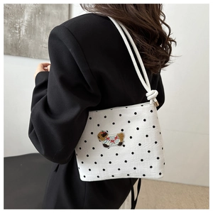 Détail d'un sac cabas blanc à pois avec broderie de mouton et bandoulière en corde