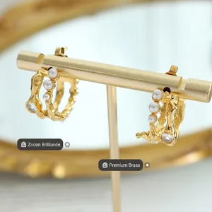 Vintage French irregular C-shaped gold hoop earrings with pearls and zircon on display