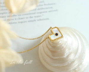Macro di una collana a cuore in oro 18 carati con madreperla e pietra preziosa blu