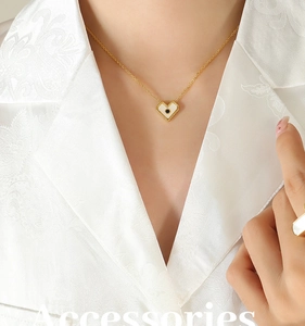 Primo piano della collana con ciondolo a cuore dorato e inserto in madreperla