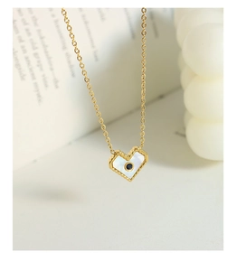 Dettaglio della collana con cuore in madreperla e zircone blu su catena d'oro fine