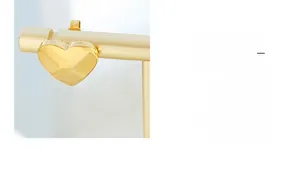 Macro detail of polished gold heart-shaped earring on a gold display stand