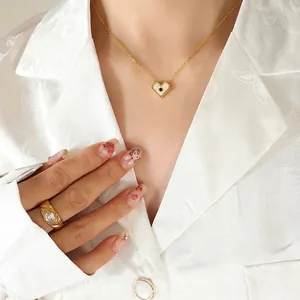 Collana con cuore dorato e conchiglia bianca con anello in zircone su camicia di seta