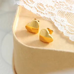 Polished 18K gold plated titanium steel heart stud earrings for women on lace background