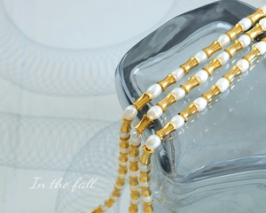 Dettaglio della collana di perle d'acqua dolce con distanziatori in bambù dorato su vetro