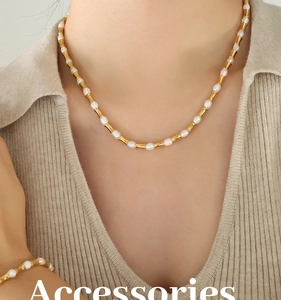 Dettaglio della collana a catena in oro stile bambù e set di perle su maglione