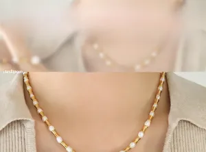 Dettaglio di maglie in bambù dorato e perle bianche su una collana vintage in stile hip hop