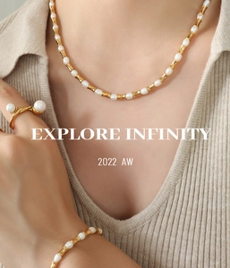 Dettaglio di elegante set collana e bracciale con perle e metallo dorato stile bambù