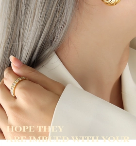 Macro d'une bague taille baguette dorée et boucle d'oreille texturée sur mannequin