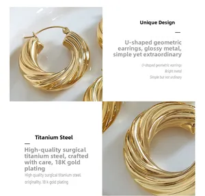 Détail macro de boucles d'oreilles en U torsadées en acier titane plaqué or 18 carats
